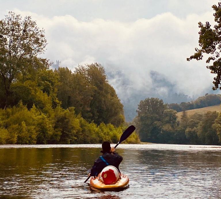 Hombre en canoa disfrutando del tiempo en Arriondas en agosto mientras hace el descenso río Sella
