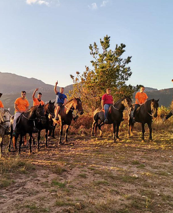 Grupo de personas montadas a caballo haciendo rutas a caballo con niños en Asturias