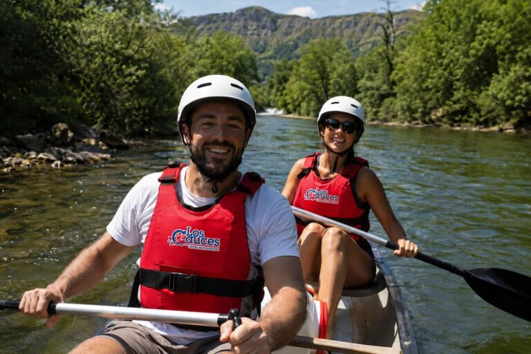 Dos personas disfrutando del Descenso del Sella en kayak con chalecos rojos de Los Cauces y paisaje natural de Asturias.