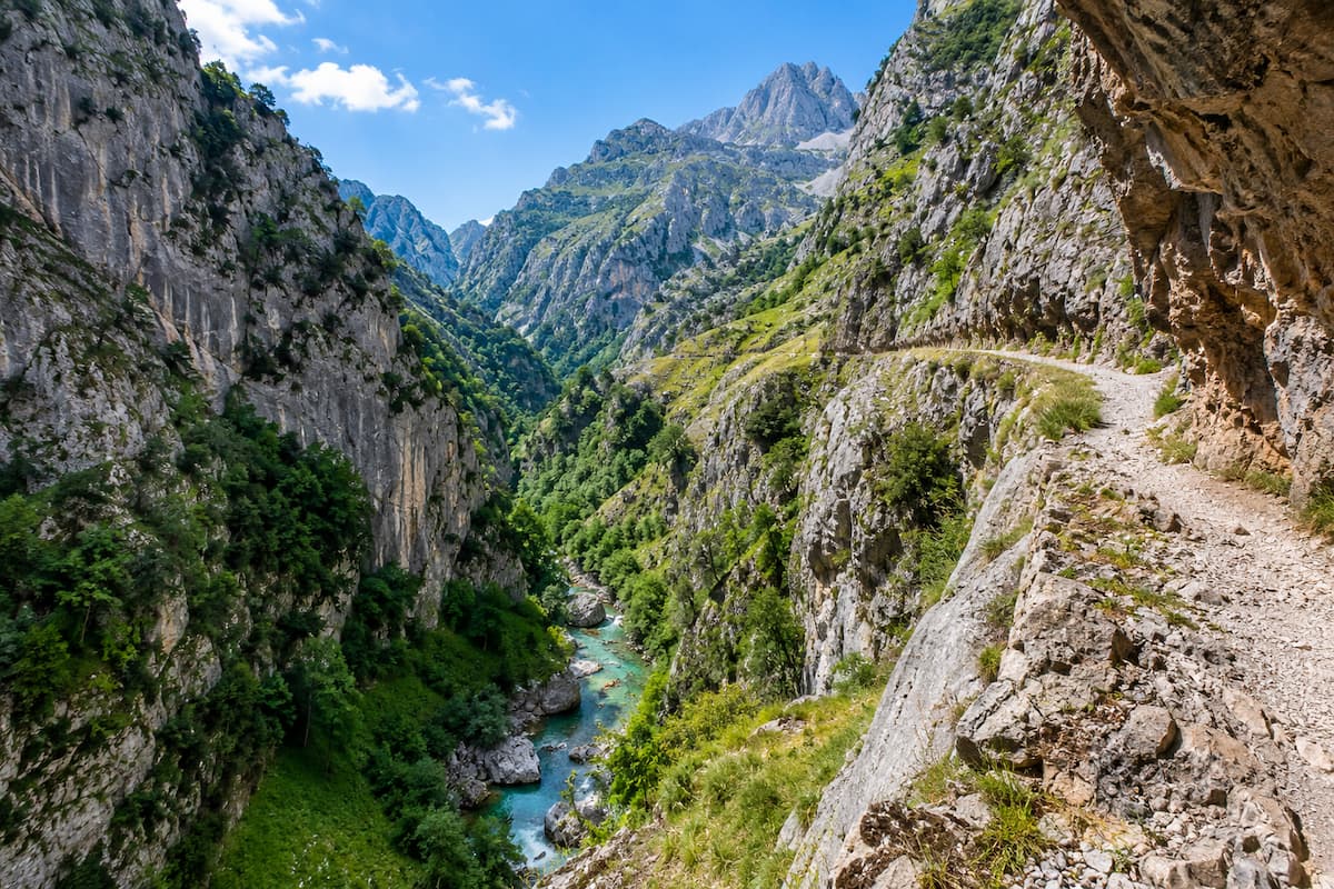 Tramo panorámico de la Ruta del Cares con sendero junto al precipicio y el río Cares entre montañas